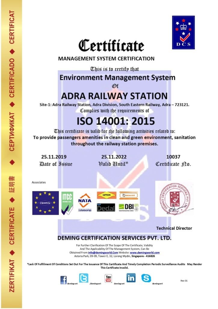 Management System Certificate issued by Deming Certification Services Pvt. Ltd. certifying Adra Railway Station (Adra Division, South Eastern Railway) for ISO 14001:2015 Environment Management System compliance, featuring a vertical gold margin on the left and international accreditation badges along the bottom.